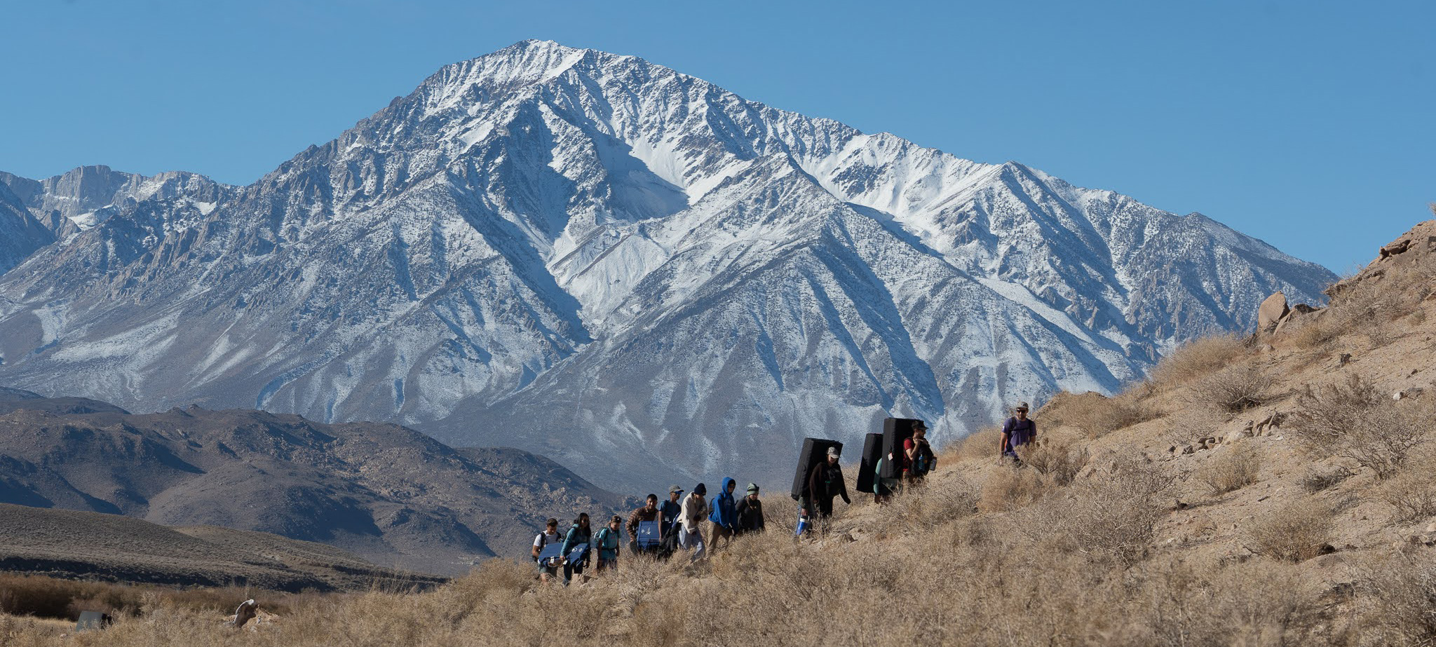 Group hiking with scenic mountain range in background