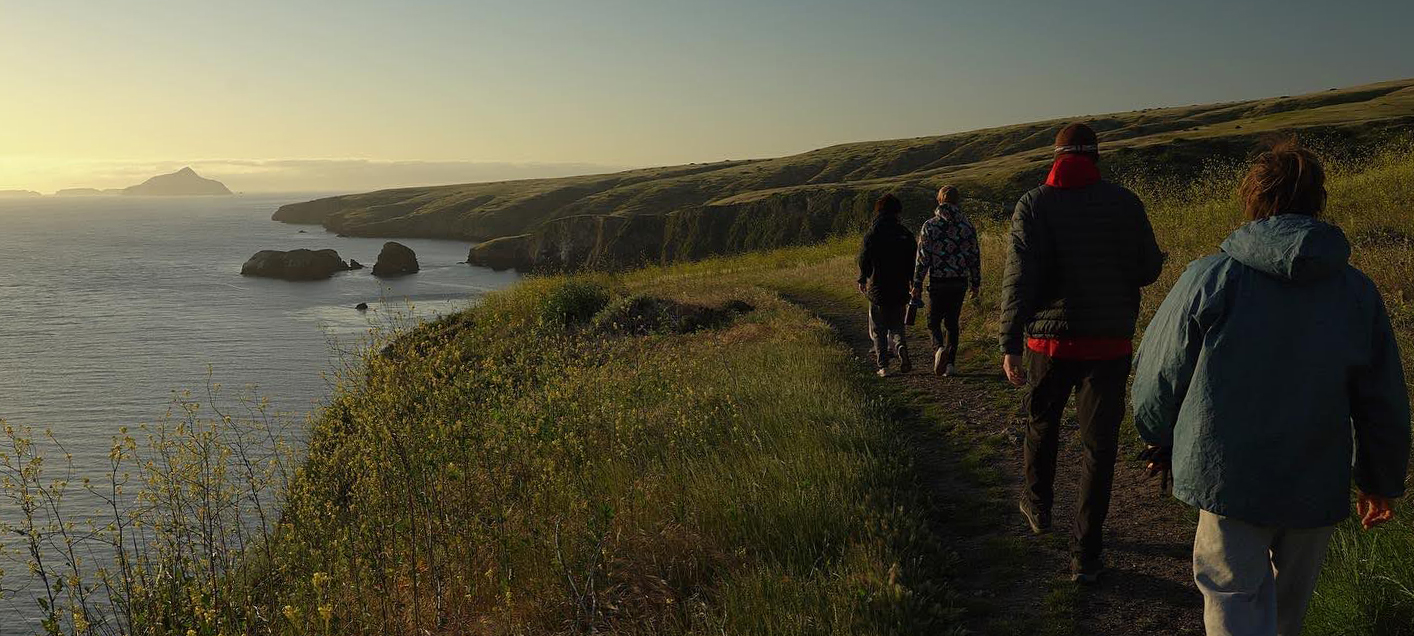 Group walking along a cliff over the ocean