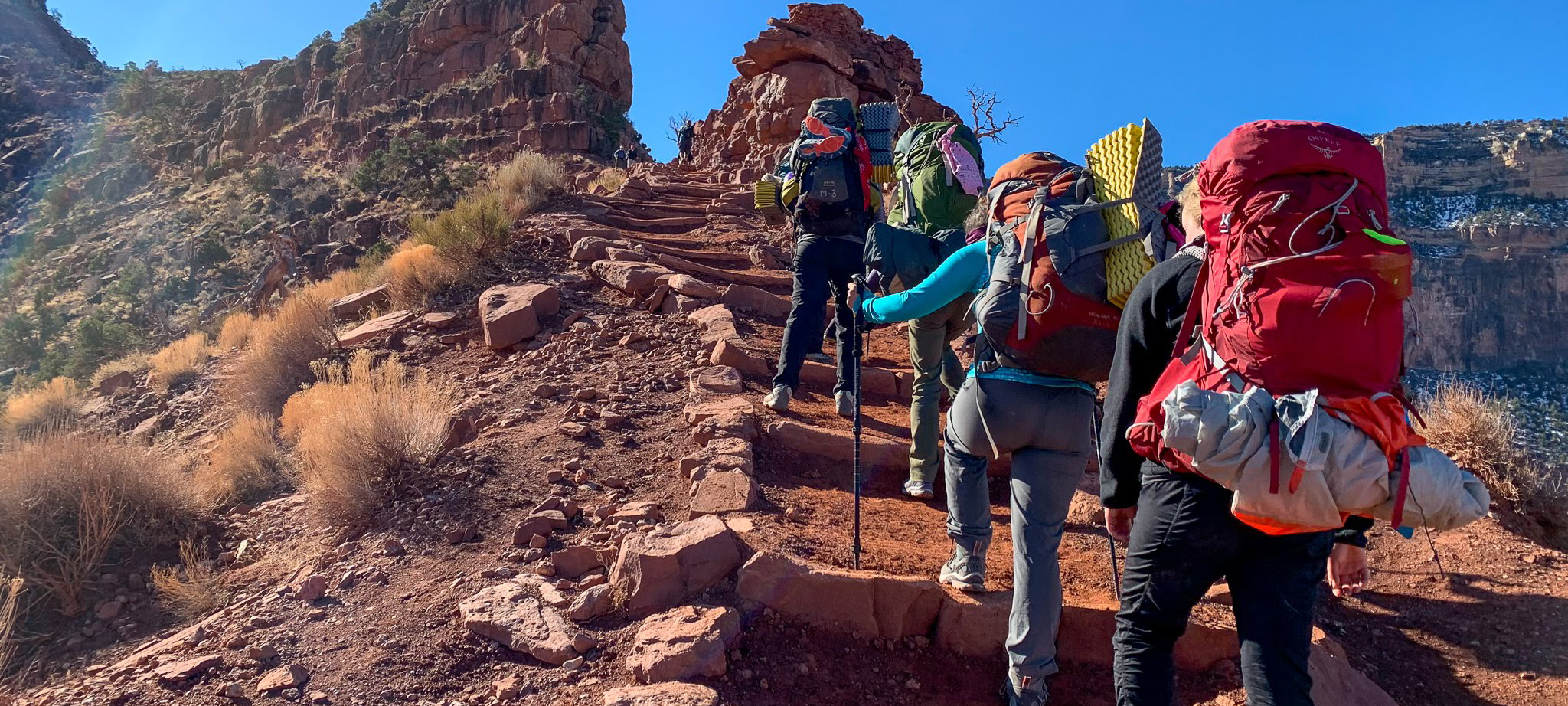 Students hiking up a rocky path