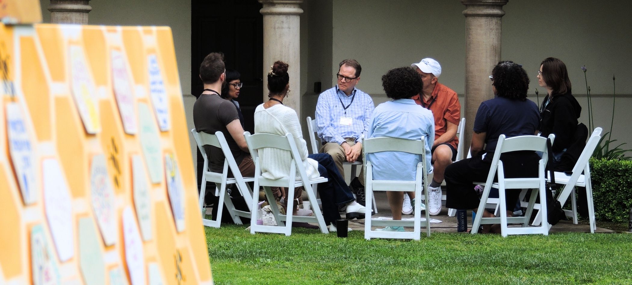 people sitting in a circle with a board of positive words