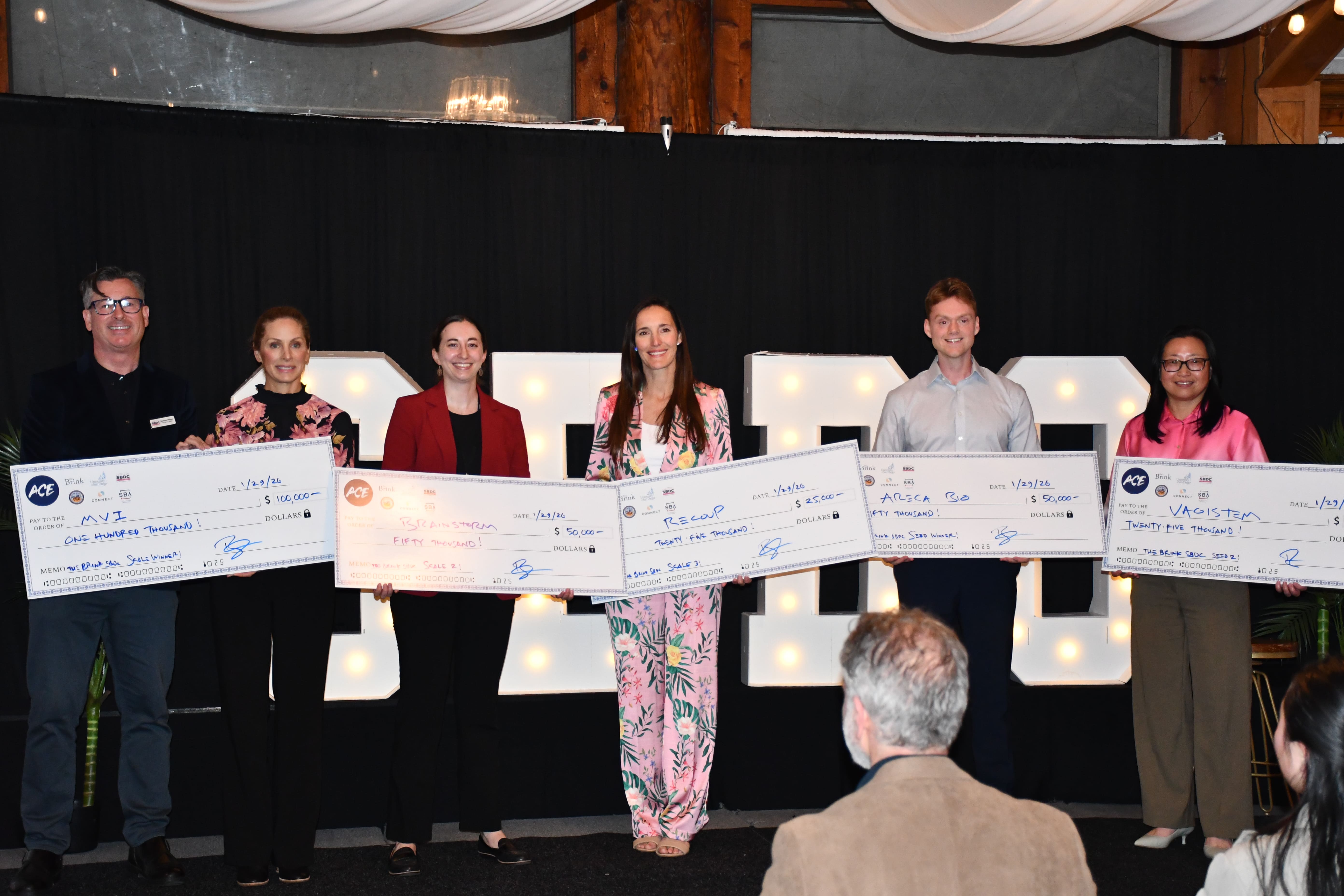 group of people holding awards/prizes on stage