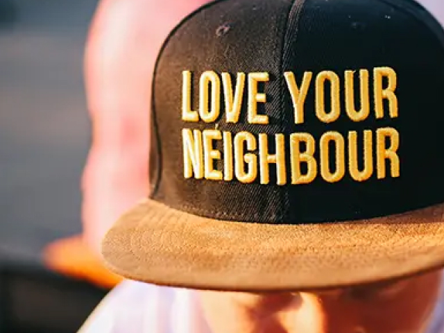 person wearing a hat that says love your neighbor