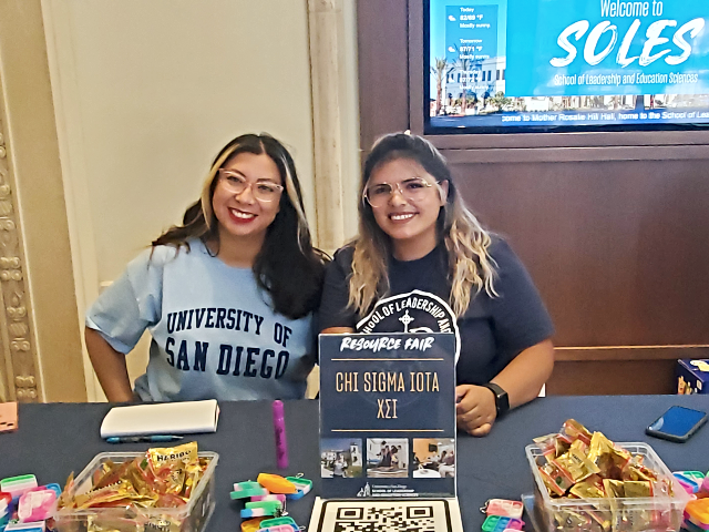 two females sitting behind the table for Chi Sigma Iota