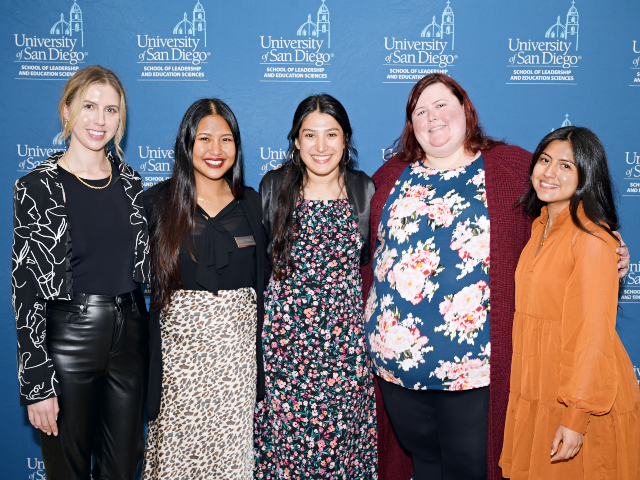 five women standing together smiling