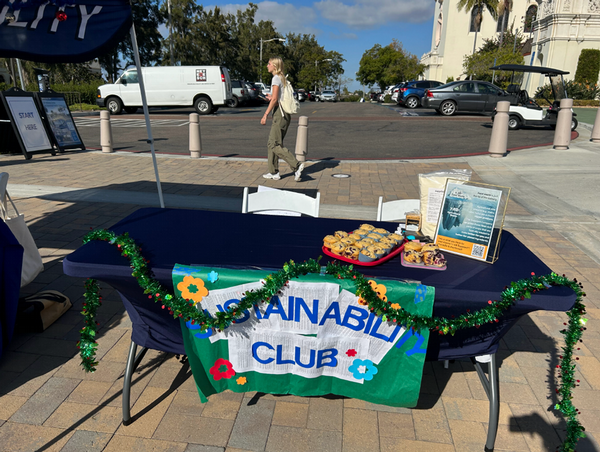 Sustainability Club table with holiday decorations and the Immaculata parking lot in the background