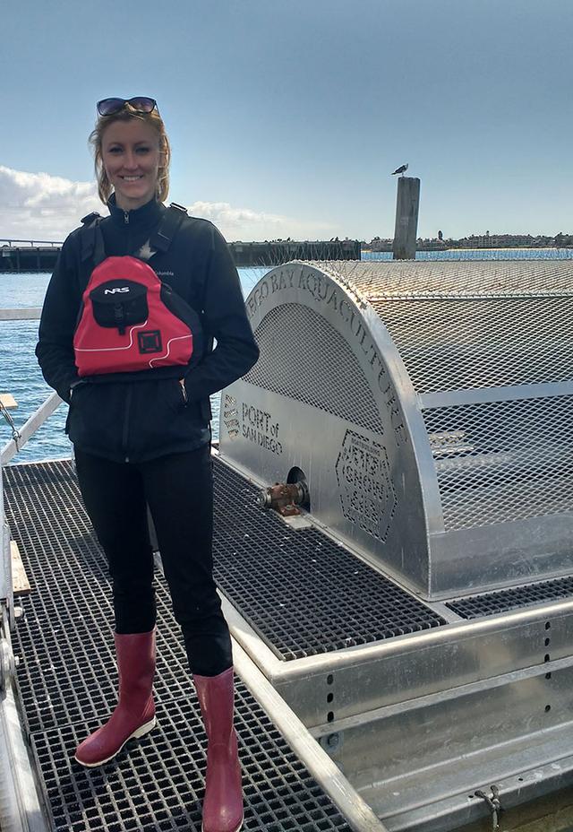 Laura stands by a large metal instrument