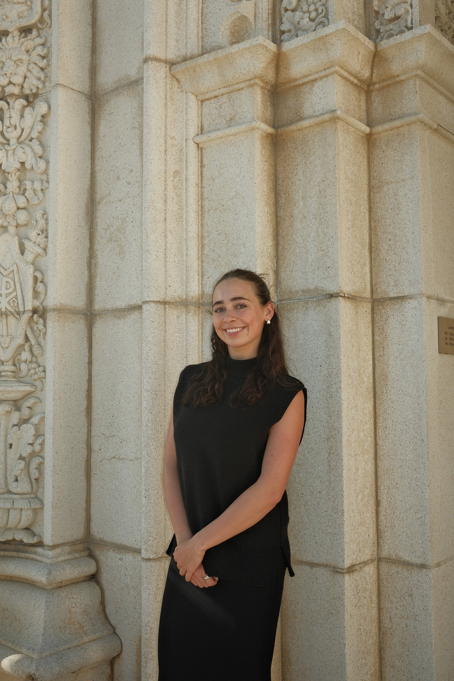 LoLo Landry smiling and standing in front of a stone wall