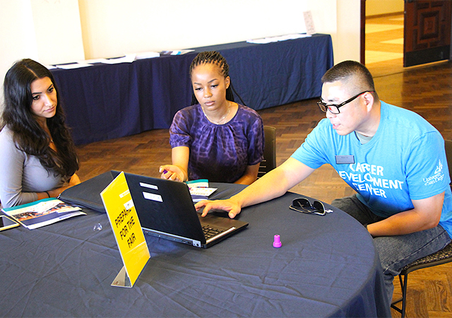 Career Development Center 's Alex Lo, far right, works with students during Tuesday's Career Cafe event in the UC Forums.
