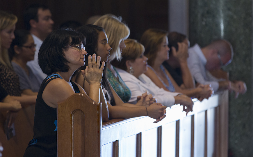 people kneeling at church and praying