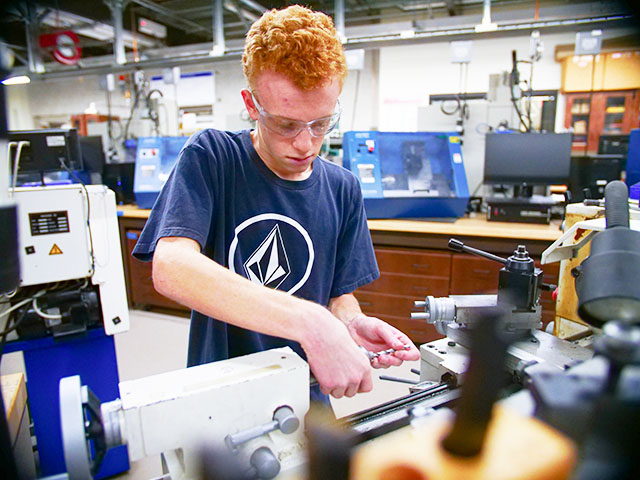 SURE student Christopher Angelo in the machine shop