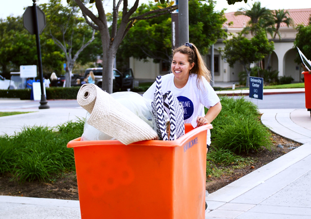 Student pushes a cart toward her residence hall during move-in day at USD.