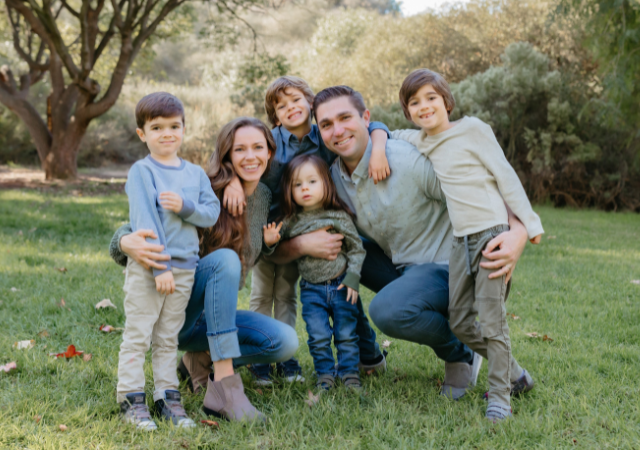 Image of 6 people on a grassy field smiling.