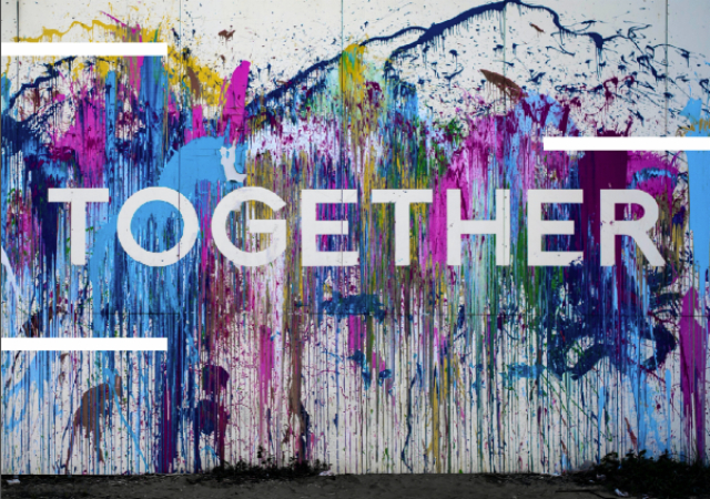 Paint splattered wall, spelling out the word together