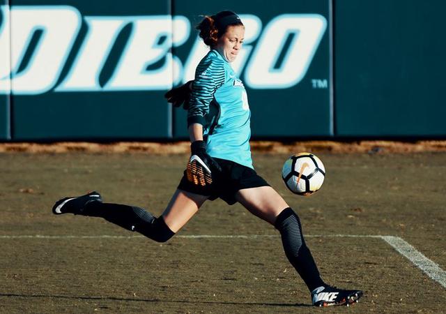 USD women's soccer goalie Amber Michel kicks a ball.