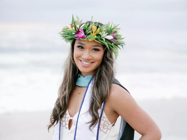 Photo of KAPRI TULANG-DE SILVA in a USD white stole and haku lei on her head