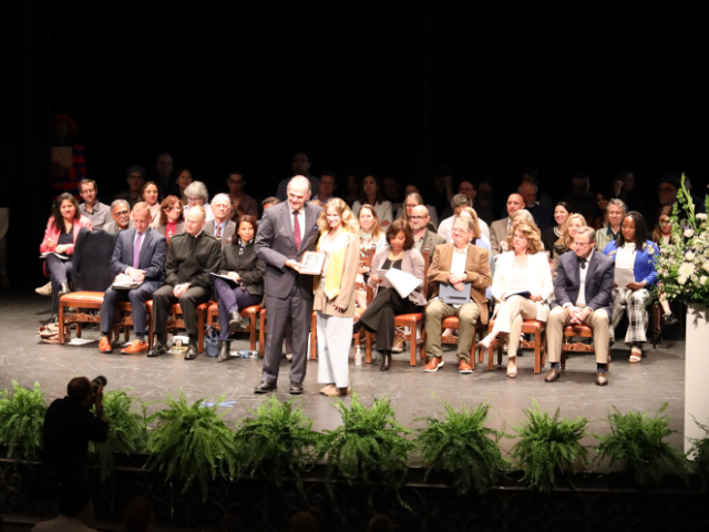 president harris and student recipient on stage at the 2023 honors convocation.