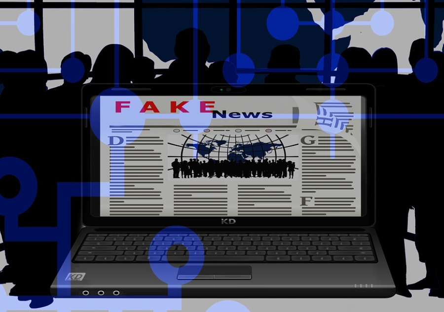 laptop on a website that looks like a newspaper that says "fake news"