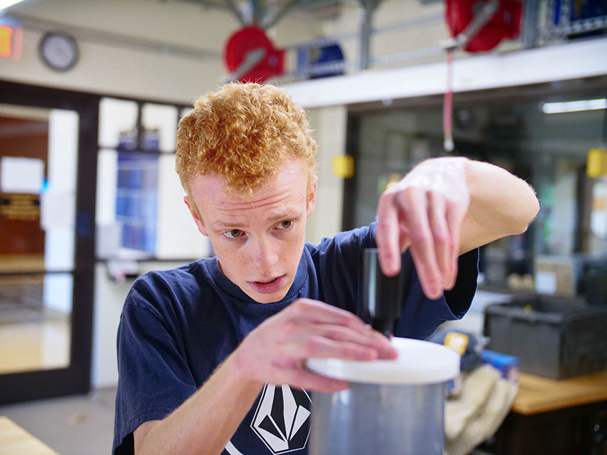 SURE student Christopher Angelo in the machine shop