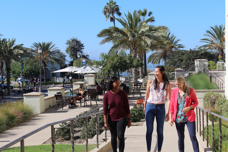 A black woman, asian woman, and white woman walk together at University of San Diego campus