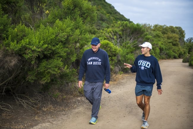 USD President James T. Harris walks with a student in Tecolote Canyon