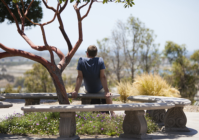 student looking towards ocean, deep in thought