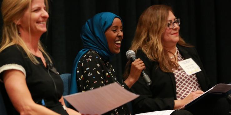 three women panel speakers laughing and smiling