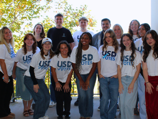 An image of 15 people wearing USD Votes shirts