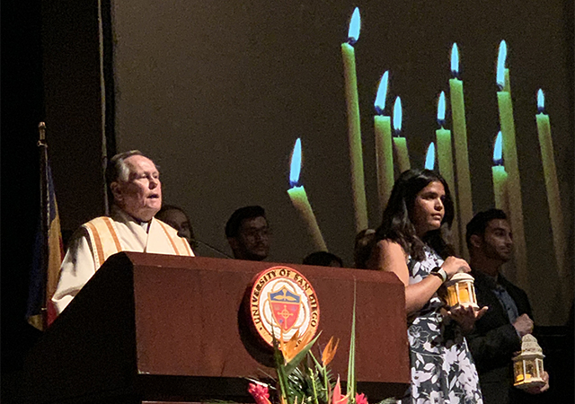 Monsignor Daniel J. Dillabough welcomes the audience in Shiley Theatre to the 27th annual All Faith Service at USD.