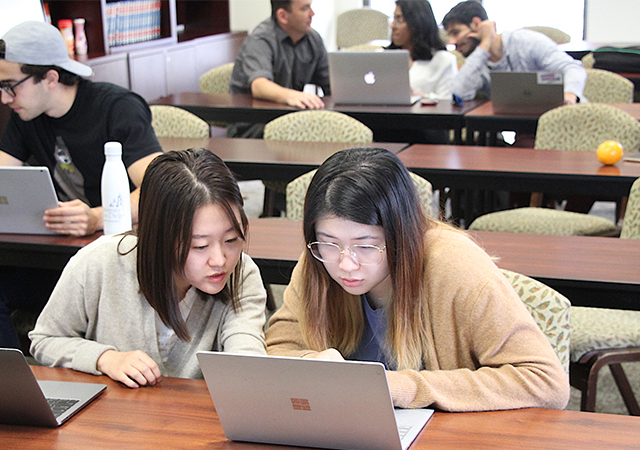 Students work together on a class assignment for the USD School of Business Master of Science in Business Analytics degree program.