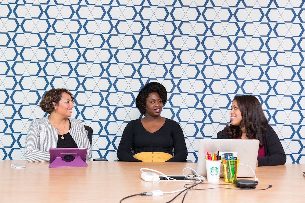 Diverse women discuss business at a table