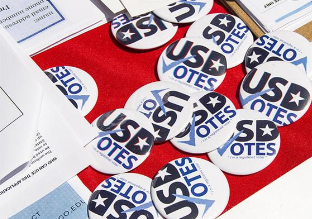 Table with clipboards and buttons that say USD Votes