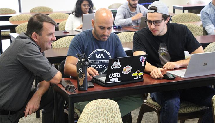 Students work together on a class assignment for the USD School of Business Master of Science in Business Analytics degree program.