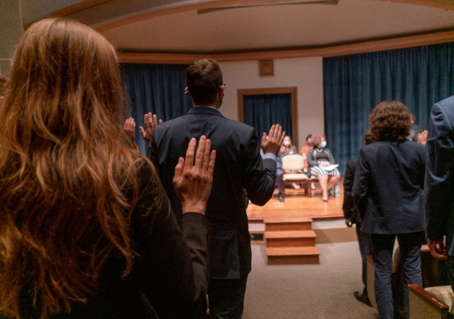 Students with their right hand up taking the oath of professionalism
