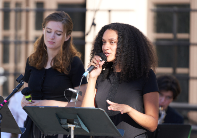 Three singers and a saxophone player from the Jazz Ensemble perform