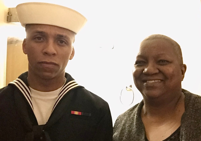USD student veteran Jack Atkinson poses with his mother for a photo while wearing his U.S. Navy uniform.