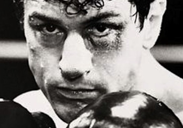 Move still of a closeup of Robert De Niro's character in boxing gloves.