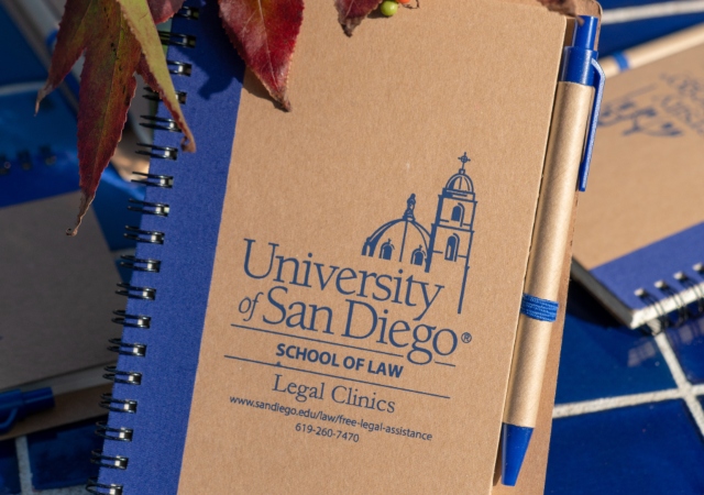 Notebook with USD School of Law Legal clinics logo on it