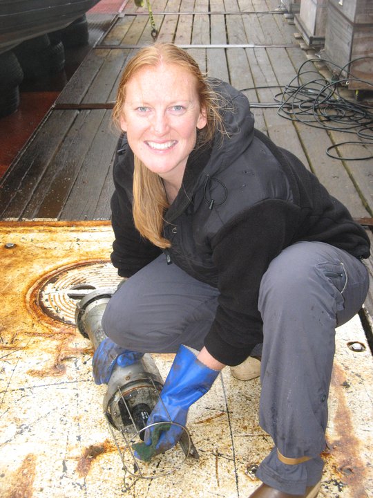 Jessica holds and instrument on a boat.