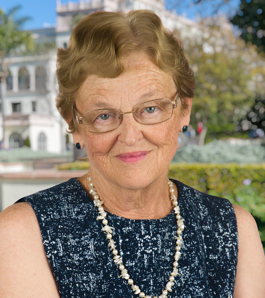 Headshot of Florence in a sleeveless black top, long strand of beads and her head tilted slightly.