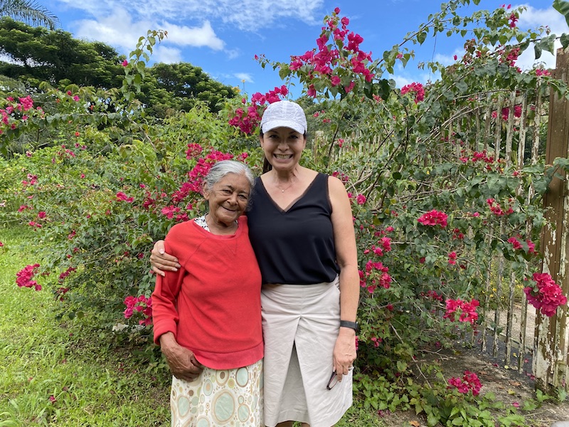 University of San Diego alumna Maria Ridge ‘08 smiles with a local woman in front of a lush, green background in Puerto Rico