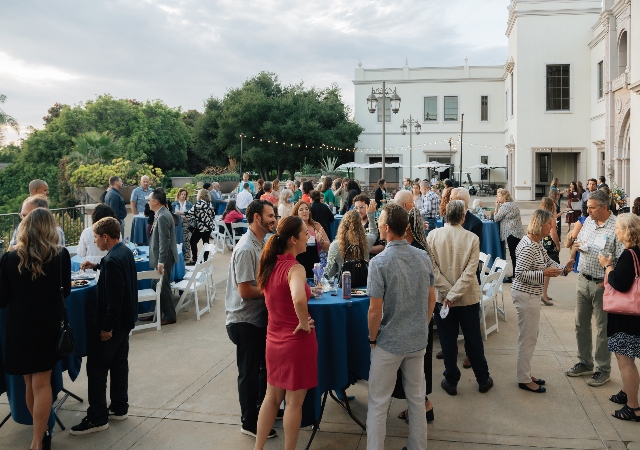 Crowd of people at an outdoor reception on the University of San Diego Campus
