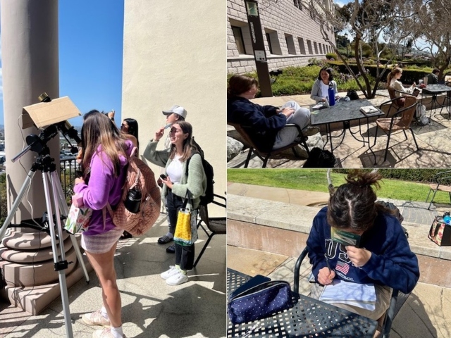 Students viewing solar eclipse through sun telescope and sitting at courtyard tables writing 