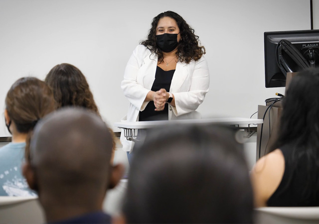 Image of Cassidy De Anda Gamboa presenting to audience members on her research