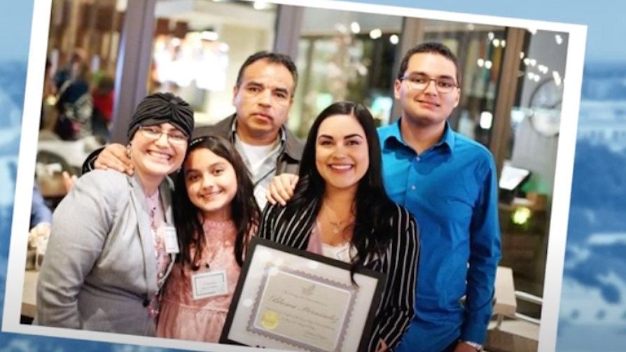 Blanca Hernandez smiles with her family while holding her USD business degree