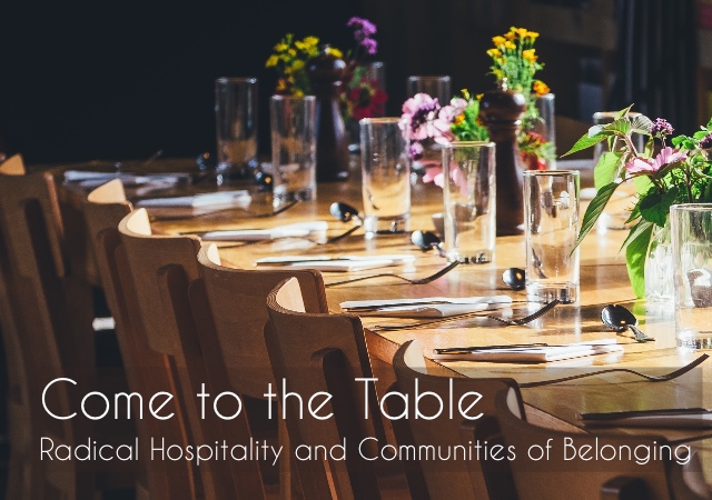 a wooden table with an empty place setting of a silver plate and utensils