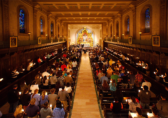 image of founders chapel with mass attendees holding candles 