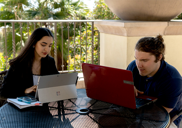 Image of HBN team working on their computers at a table behind SOLES