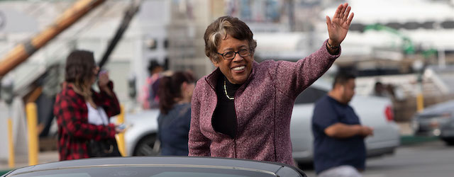 Dr. Constance Carroll waving from a car in a parade