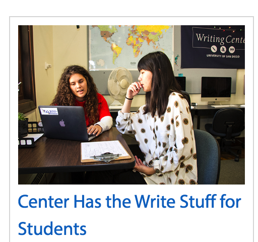 Two students working on assignment together in front of laptop computer