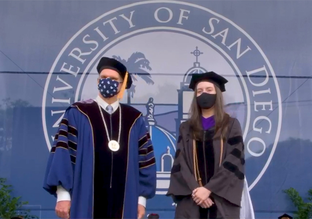 Photo of USD law graduate with President Harris during Commencement